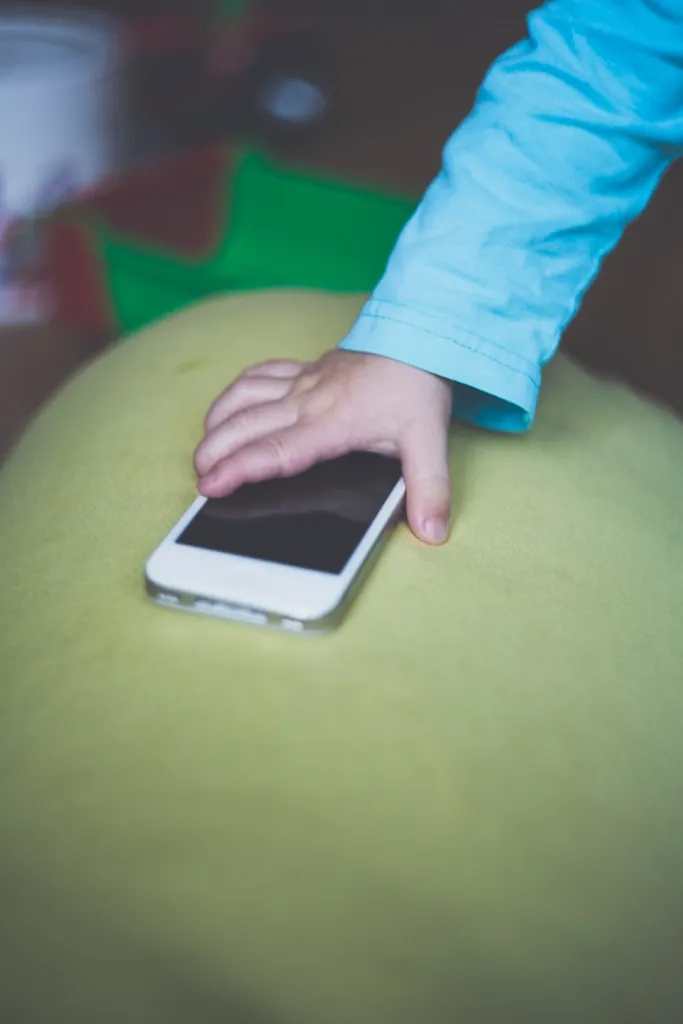 Małe dziecko sięga po smartfon